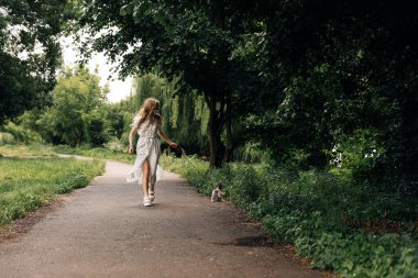 Maskeli kadın kedisiyle yürüyor.