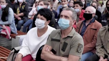 Dışarıda maskeli bir adam ve kadın var.