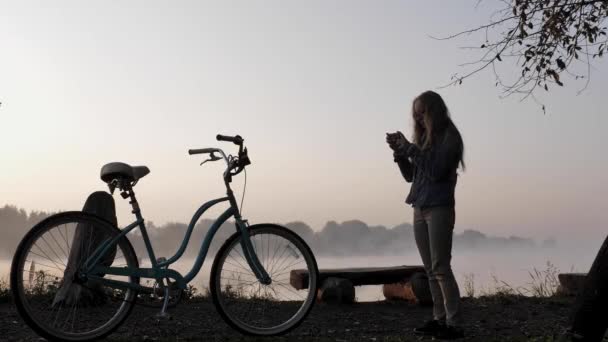 Vrouw schiet fiets op mobiele telefoon — Stockvideo