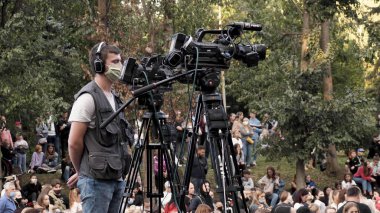 Koruyucu tıbbi maskeli bir kameraman.