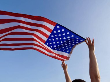 Bağımsızlık Günü bayrağı, rüzgarda dalgalanan mavi gökyüzünün arka planına karşı. Kapat.