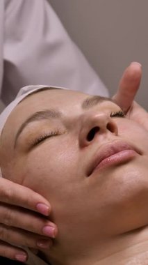 Güzellik uzmanı C vitamini serumunu pigmentasyona karşı antioksidan ve kırışıklıklara karşı kadın yüzüne uyguluyor. Güzellik salonunda profesyonel bakım.