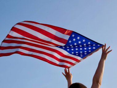 A U.S. flag waves against a clear sky, symbolizing American freedom and patriotism. Its perfect for celebrating Constitution Day and national pride