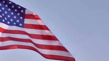 A U.S. flag waves against a clear sky, symbolizing American freedom and patriotism. Its perfect for celebrating Constitution Day and national pride