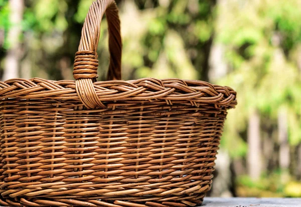 Empty basket picnic on table place. Sunny natural rustic background