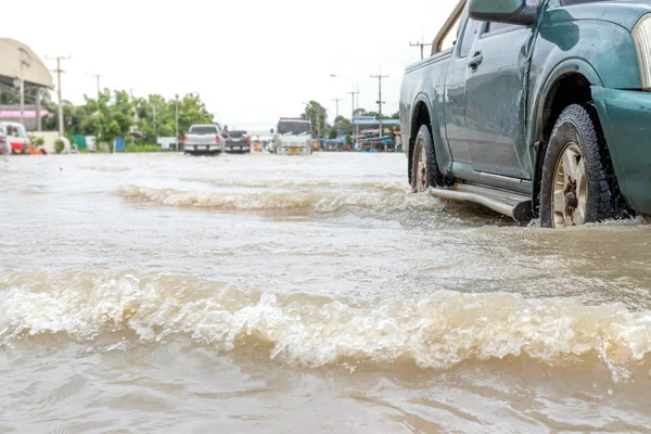 Carros dirigindo em uma estrada inundada, o carro quebrado está estacionado em um fl — Fotografia de Stock