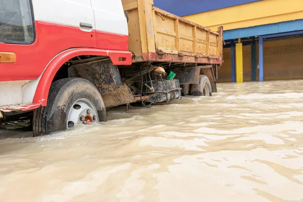 Carros dirigindo em uma estrada inundada, o carro quebrado está estacionado em um fl — Fotografia de Stock