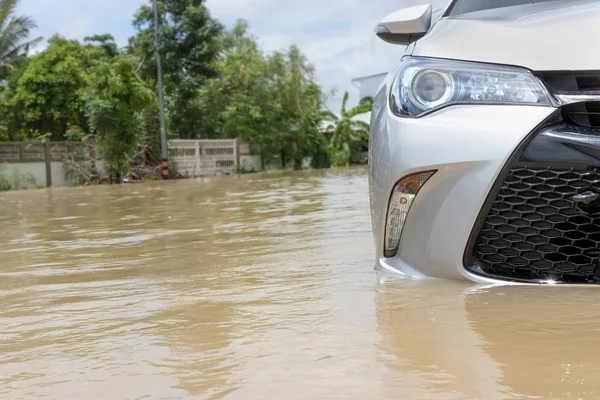 Voiture conduite sur une route inondée, La voiture cassée est garée dans un fl — Photo