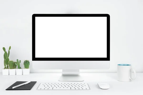 带有空白空白文字复制空间的计算机 Mockup设计的办公室台式计算机 白色桌子上有键盘和咖啡杯 工作场所概念 锅中的仙人掌 图库照片