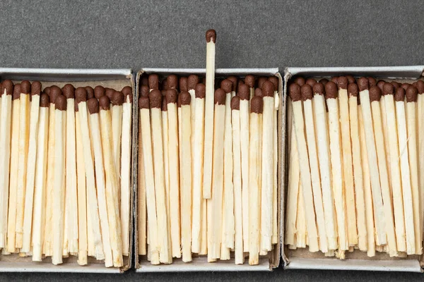 Matchboxes full of matches is placed over gray background, with place for your text and design. One match is above other ones. Concept of leadership. Close-up shot, top view — Stock Image Matchboxes Full Matches Placed Gray Background Place Your Text Design Royalty Free Stock Photos