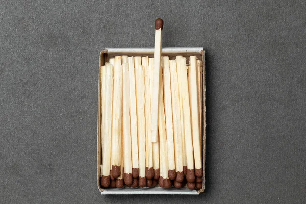 Matchbox full of matches is placed over gray background, with place for your text and design. One match is above other ones. Concept of leadership. Close-up shot, top view — Stock Image Matchbox Full Matches Placed Gray Background Place Your Text Design Stock Image