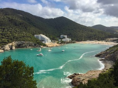 Güneşli yaz gününde beyaz bulutlarla dolu güzel Akdeniz Cala Llonga Koyu, İbiza Adası, İspanya