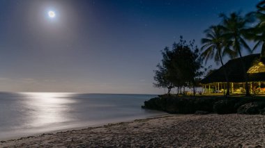 Su, Zanzibar, Tanzanya yansıtan ay ışığı gümüş parıltı ile bir cennet plaj güzel gece görünümü