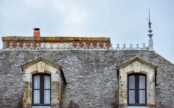 Dormer windows on slate roof and orange chimneys. Rochefort-en-Terre, French Brittany