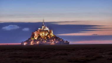 Işıklı Mont Saint Michel yaz aylarında bulutlar ile renkli bir gökyüzünde alacakaranlıkta, Fransa