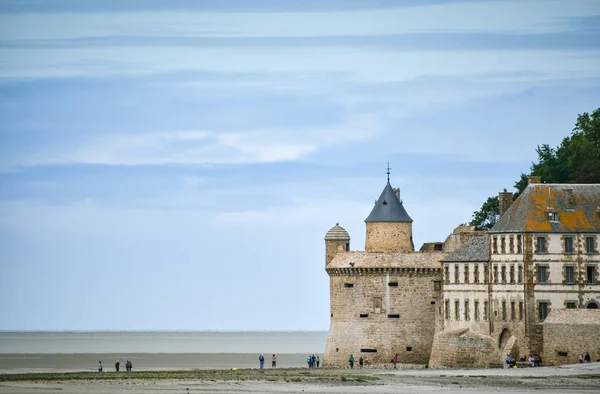 Turister på stranden och ett av tornen i muren av Mont Saint Michel, Frankrike. — Stockfoto