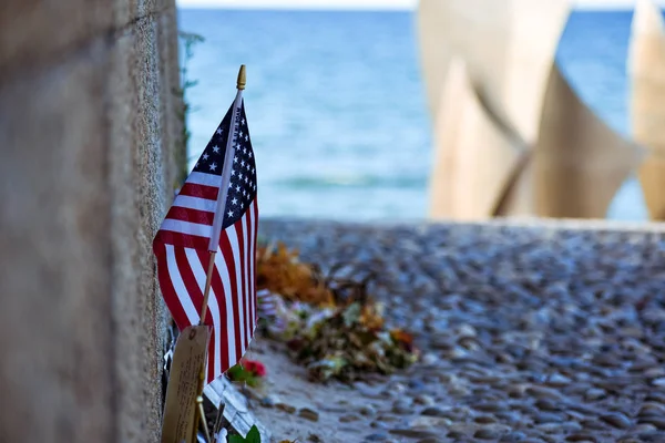 United States flag, flowers and objects in memory of fallen in Normandy landing. Omaha Beach Memorial. France. — Stock Photo, Image