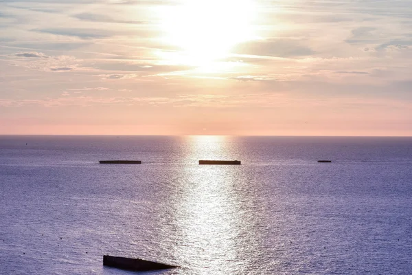 Calm sea with sunset sky. Colorful horizon over the water and Atlantic wall. Normandy, France.