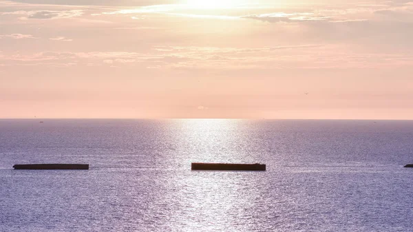 Calm sea with sunset sky. Colorful horizon over the water and Atlantic wall. Normandy, France.