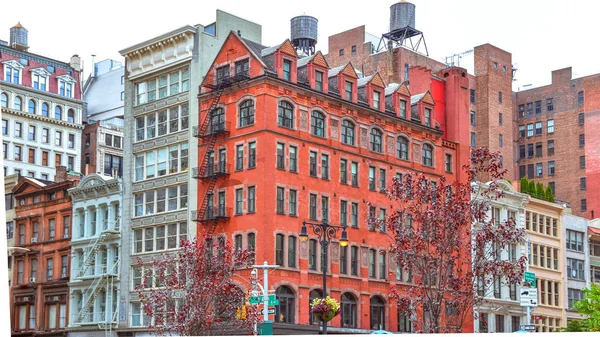 Bâtiments en briques colorées, avec fenêtres et escaliers de feu. Dépôts d'eau sur les toits. NYC, États-Unis — Photo