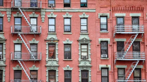 Façade en brique rouge, et escaliers de feu. Harlem, NYC . — Photo