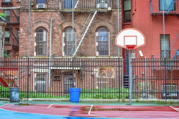 Yağmurlu bir günde boş basketbol sahası. Bir çitle çevrili ve evler arasında. Harlem, Nyc, Amerika Birleşik Devletleri.