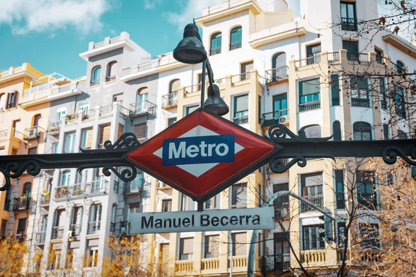 前景には地下鉄の標識マドリードと背景には焦点を当てていない建物。秋の旅行のコンセプト. — ストック写真