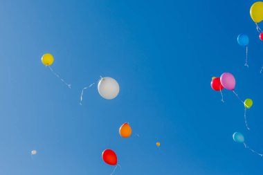 Mavi gökyüzüne doğru uçan balonlar