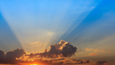 Güneş ışınları bulutları delip geçiyor. Gökyüzünde parlıyor. Işığın sembolü. Doğanın güzel manzarası.