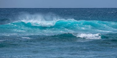 Hawaii'de kumlu bir plajda çöken çift dalgalar
