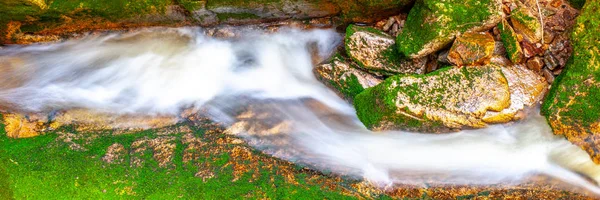 Cascata de água de pequeno riacho entre pedras musgosas. Exposição longa . — Fotografia de Stock