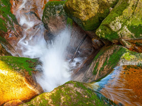 コケに覆われた石の間の小さなクリークの水のカスケード。長時間露光. — ストック写真