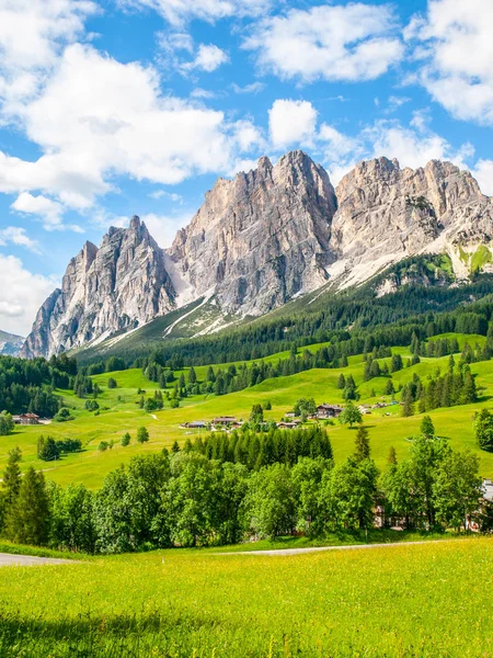 Skalnatý hřeben hory Pomagagnon nad Cortina dampezzo s zelené louky a modré nebe s bílými letní mraky, Dolomity, Itálie — Stock fotografie