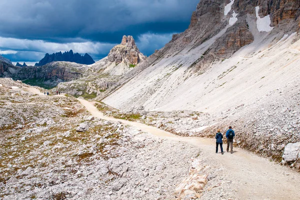 Escursionisti di montagna con bastoncini da trekking camminano sul sentiero roccioso in montagna. Tema Nordic Walking — Foto Stock