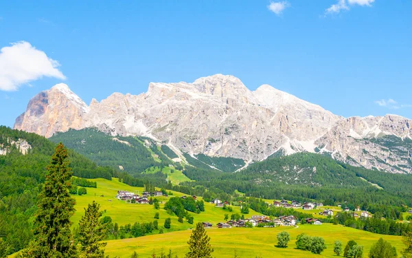 Paisaje de Dolomitas con prados verdes, cielo azul, nubes blancas y montañas rocosas —  Fotos de Stock