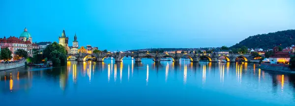 Ponte Carlo illuminato riflesso nel fiume Moldava. Panorama serale di Praga, Repubblica Ceca. Colpo panoramico — Foto Stock