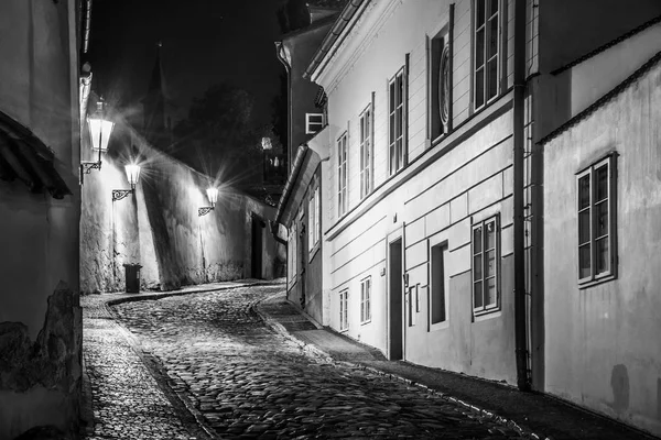 Narrow cobbled street in old medieval town with illuminated houses by vintage street lamps, Novy svet, Prague, Czech Republic. Night shot — Stock Photo, Image