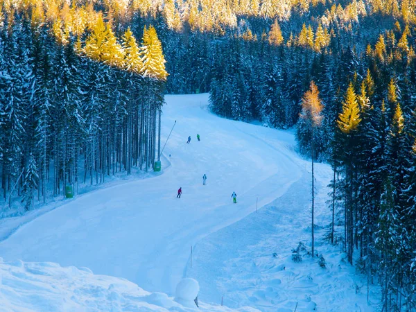 Les gens sur la piste de ski en station de montagne le matin ensoleillé d'hiver — Photo