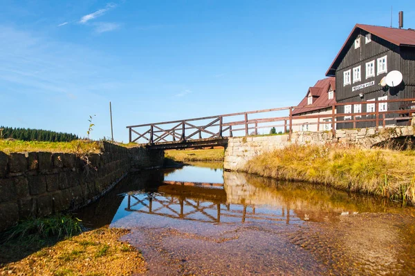 Puente sobre el arroyo Jizerka en la vieja choza de madera - Antiguo aserradero, checo: Stara pila, en el soleado día de verano. Pueblo de Jizerka, Montañas Jizera, República Checa —  Fotos de Stock