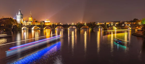 Rio Vltava com linhas de luz de néon de barco e Ponte Charles com Old Town Bridge Tower à noite, Praga, Tchecoslováquia. Património Mundial da UNESCO — Fotografia de Stock