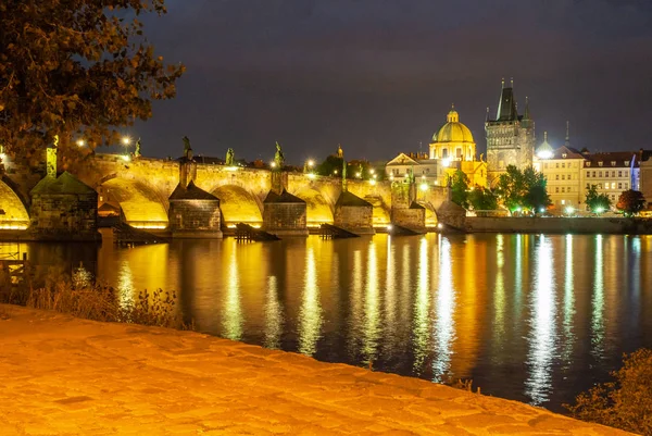 Verlichte Karelsbrug weerspiegeld in de Moldau per nacht. Prague, Tsjechië — Stockfoto