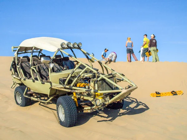 ICA, PERU - JULHO 6, 2010: Buggy de duna de areia estacionado em uma duna e grupo de pessoas se divertindo. Ica, Peru — Fotografia de Stock