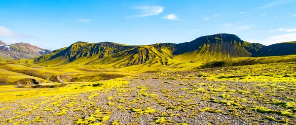 Colline verdi e terreno roccioso nero delle Highlands islandesi lungo il sentiero escursionistico di Laugavegur, Islanda. Soleggiato giorno d'estate girato — Foto Stock