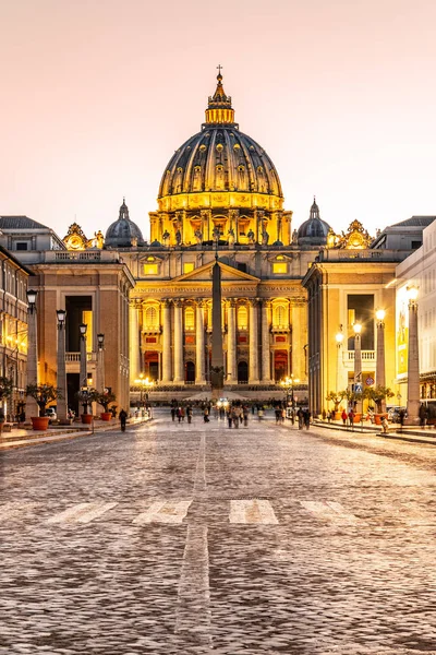 Ночью в Ватикане. Освещённый купол базилики Святого Петра и площади Святого Питера в конце улицы Via della Conciliazione. Рим, Италия — стоковое фото