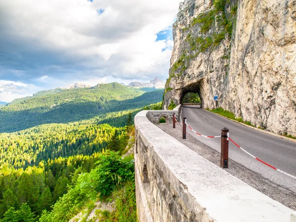 Alpská asfaltová silnice s tunelem. Lesní horská krajina nedaleko Cortiny dampezzo. Dolomity, Itálie — Stock fotografie