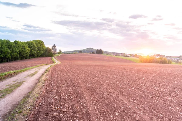 農村農業風景の田舎道。ノヴァパカ周辺の赤い土壌フィールド, チェコ — ストック写真
