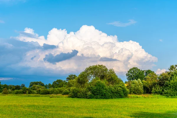 Před letní bouří. Výrazné mraky přicházející v zelené a slunečné krajině — Stock fotografie