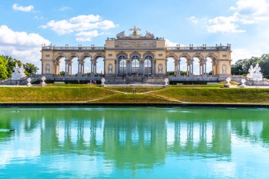 VIENNA, AUSTRIA - 23 JULY, 2019: The Gloriette in Schonbrunn Palace Gardens, Vienna, Austria. Front view and water reflection clipart