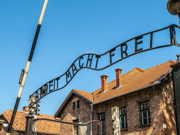 Металлическая надпись Arbeit macht frei на главных входных воротах концентрационного лагеря Освенцим, Польша — стоковое фото