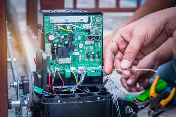 Technician assembling and testing motor automatic gate for home security system.